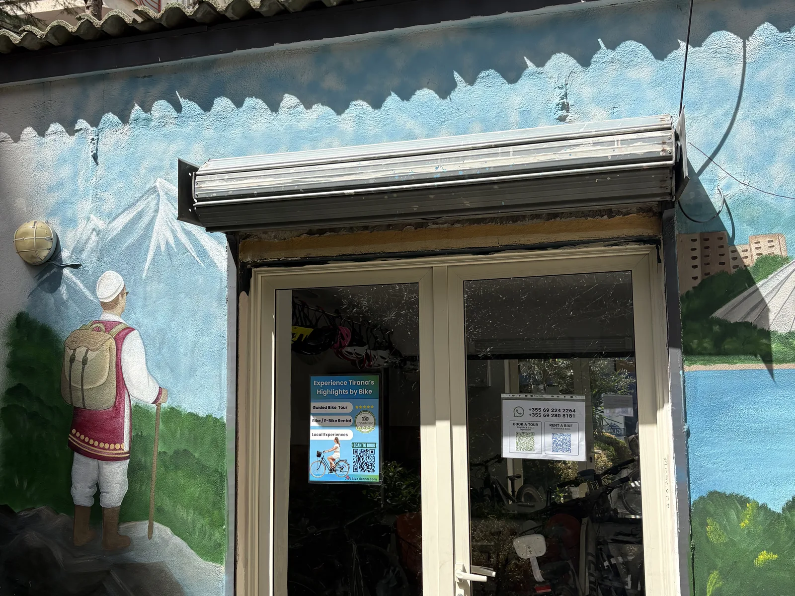 BikeTirana's entrance, rental signs and bicycles at the New Bazaar